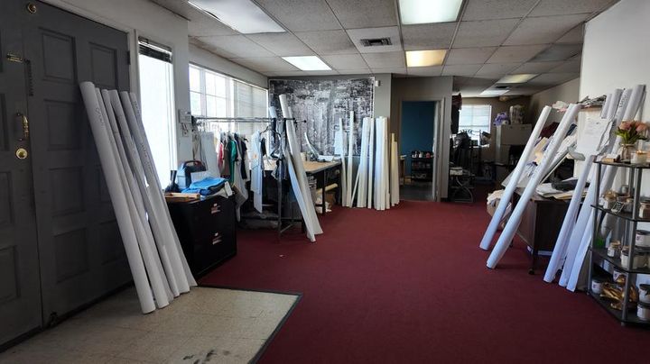 Inside Rudy's pattern shop in Vernon, CA — rolled markers, garment racks, and worktables